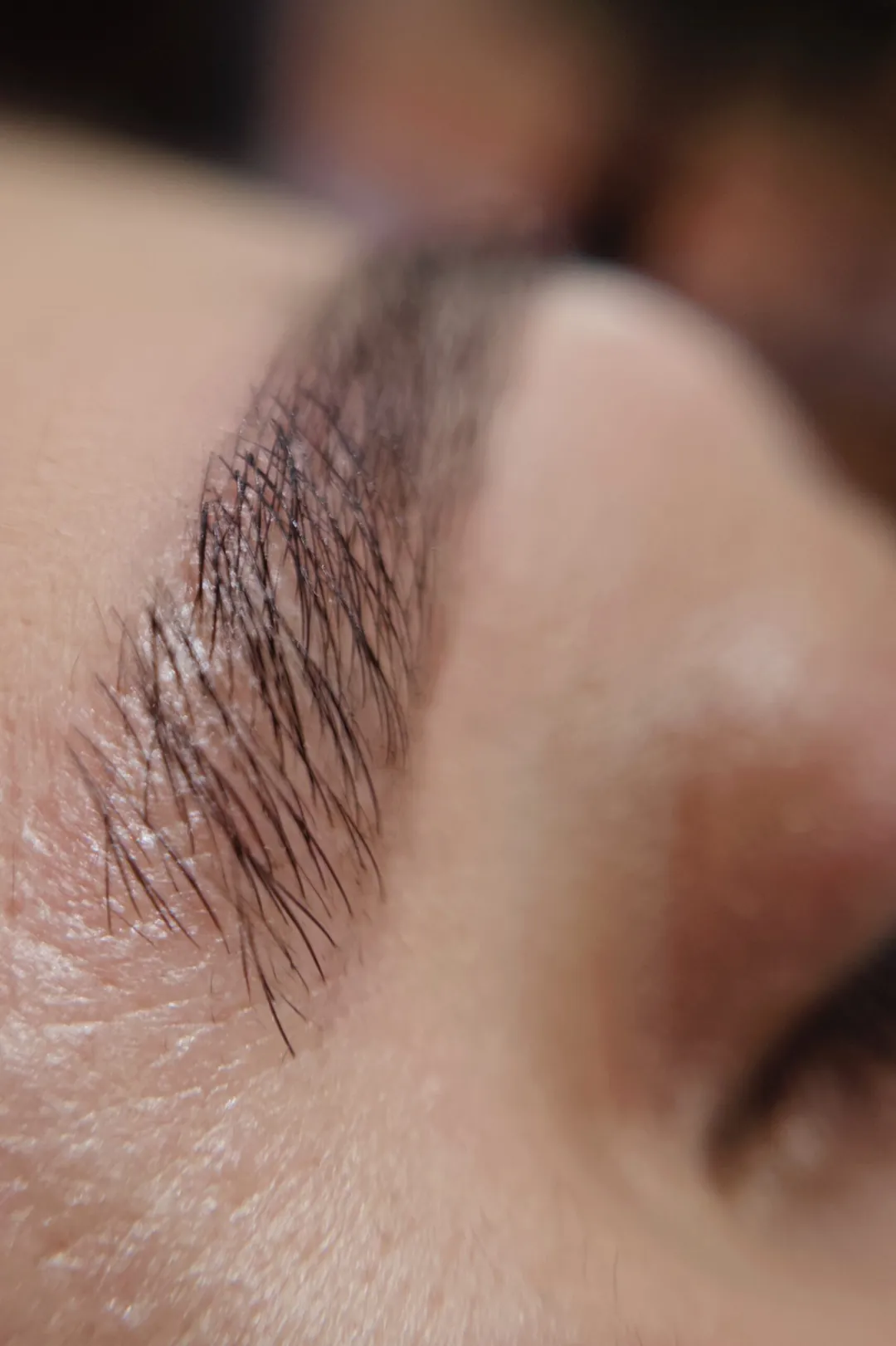 Pormenor de sobrancelha com efeito fio a fio após microblading